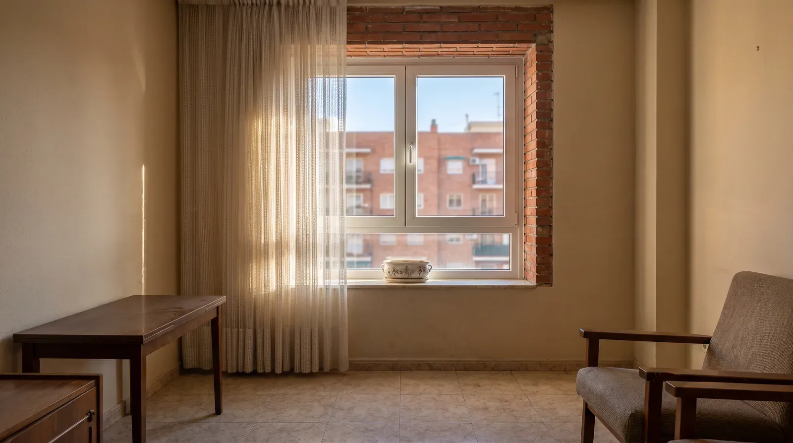 Ventana nueva de PVC blanco con doble acristalamiento colocada en la fachada de un piso de Madrid