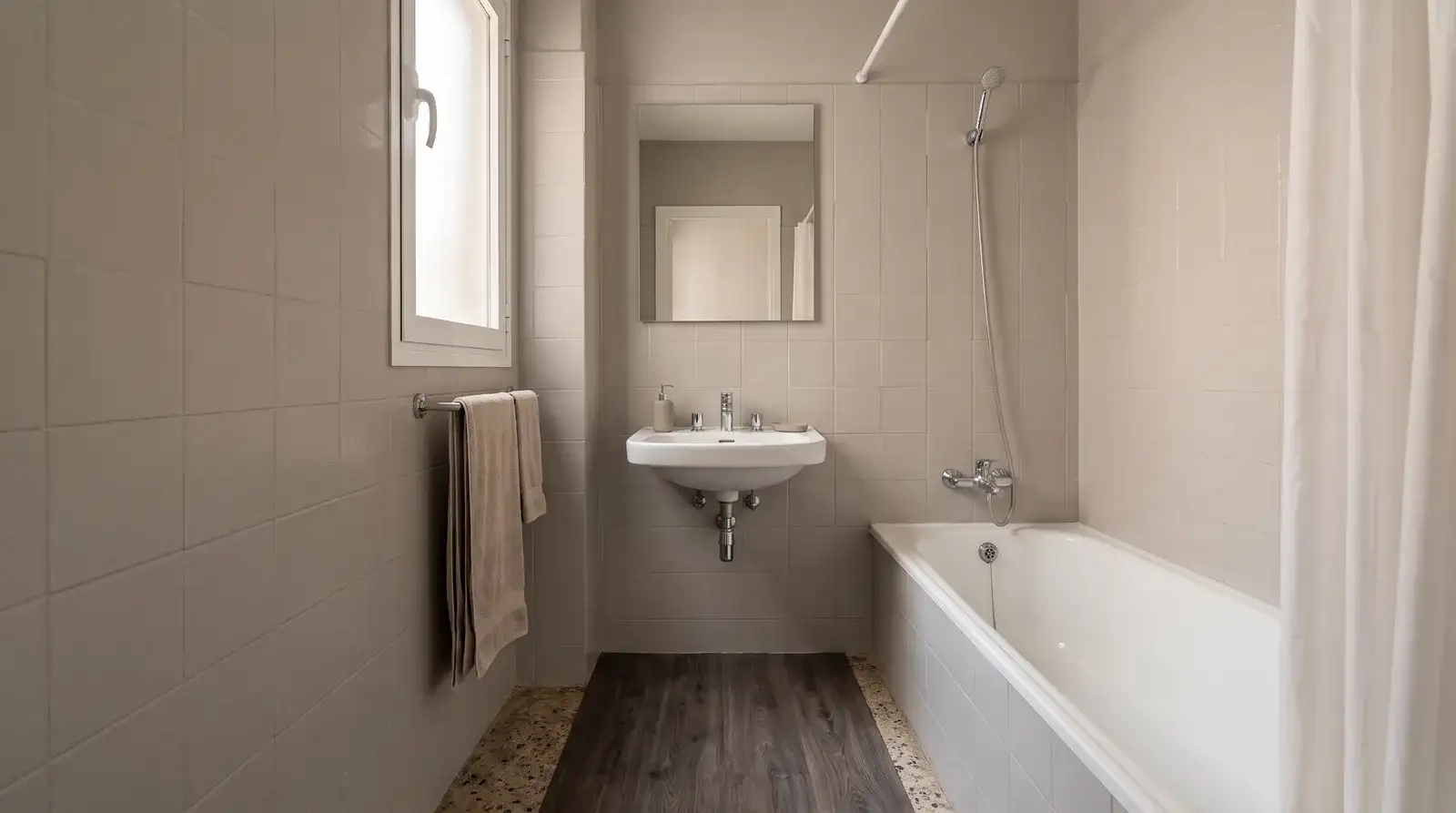 Baño antiguo renovado sin obra, con azulejos pintados en color claro y suelo vinílico sobre el solado original